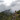 a hiker on a mountain, misty sky